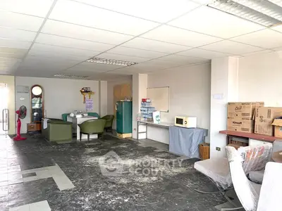 Spacious interior with potential for renovation, featuring seating area and ample natural light.