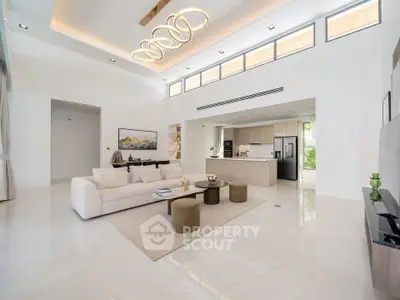 Luxurious open-plan living room with modern kitchen and elegant lighting in a spacious home.