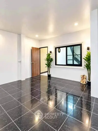 Spacious modern interior with sleek black tiled flooring and stylish decor.