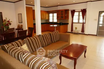 Spacious open-plan living room with elegant kitchen and dining area, featuring stylish furniture and ample natural light.