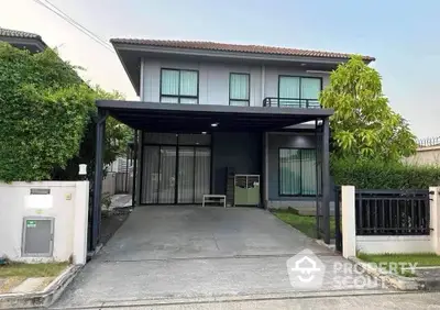 Modern two-story house with driveway and lush greenery in a serene neighborhood.