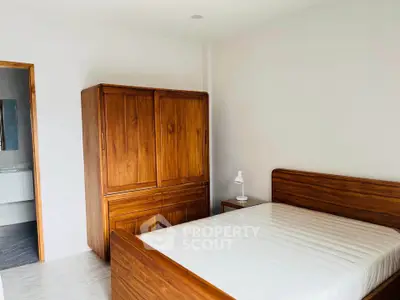 Spacious bedroom with wooden furniture and natural light