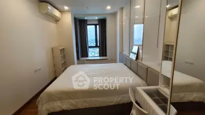 Modern bedroom with city view, featuring a comfortable bed, air conditioning, and ample natural light.