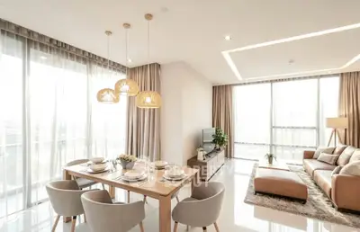 Spacious modern living room with dining area, elegant decor, and large windows for natural light.