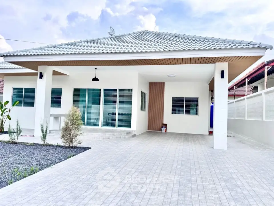 Modern single-story house with spacious driveway and elegant roof design