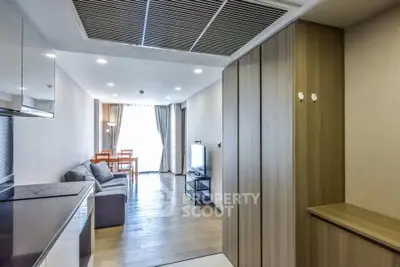 Modern living room with sleek wooden flooring and cozy seating area, perfect for relaxation and entertainment.