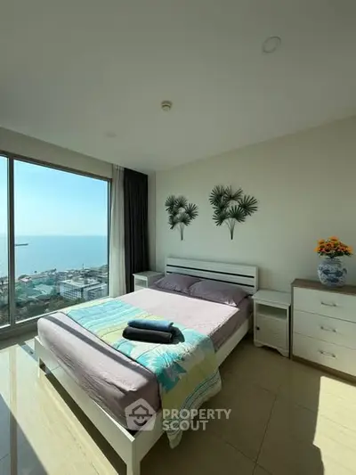 Modern bedroom with ocean view and stylish decor in a high-rise apartment.