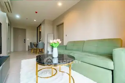 Modern living room with green sofa and elegant decor in a stylish apartment.