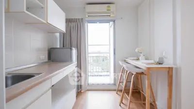 Chic modern kitchen with open layout and balcony view, perfect for urban living.