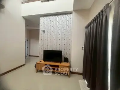 Spacious living room with high ceiling and modern decor