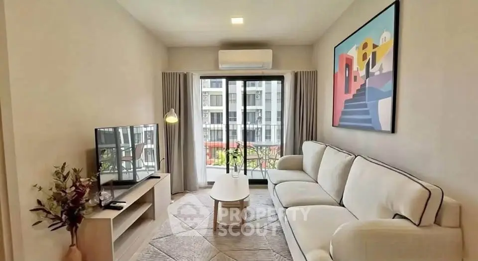 Modern living room with stylish decor and balcony view in urban apartment.