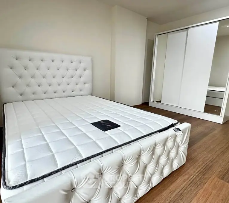 Spacious bedroom with elegant white bed and modern wardrobe in a stylish apartment.