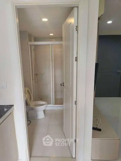 Modern bathroom with shower and toilet in a sleek apartment setting.