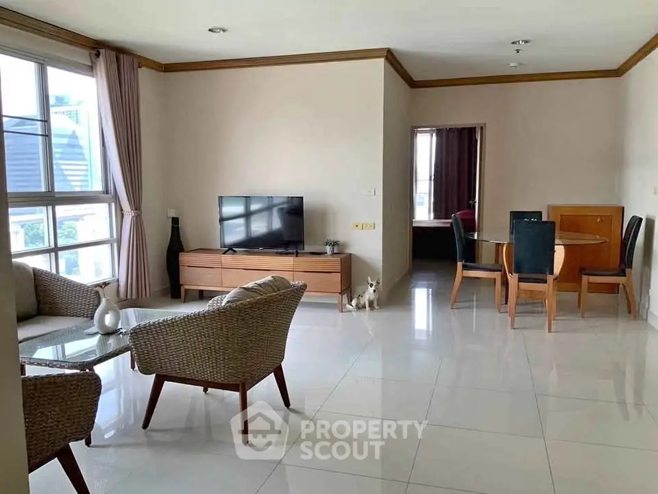 Spacious living room with modern furniture and large windows in a stylish apartment.