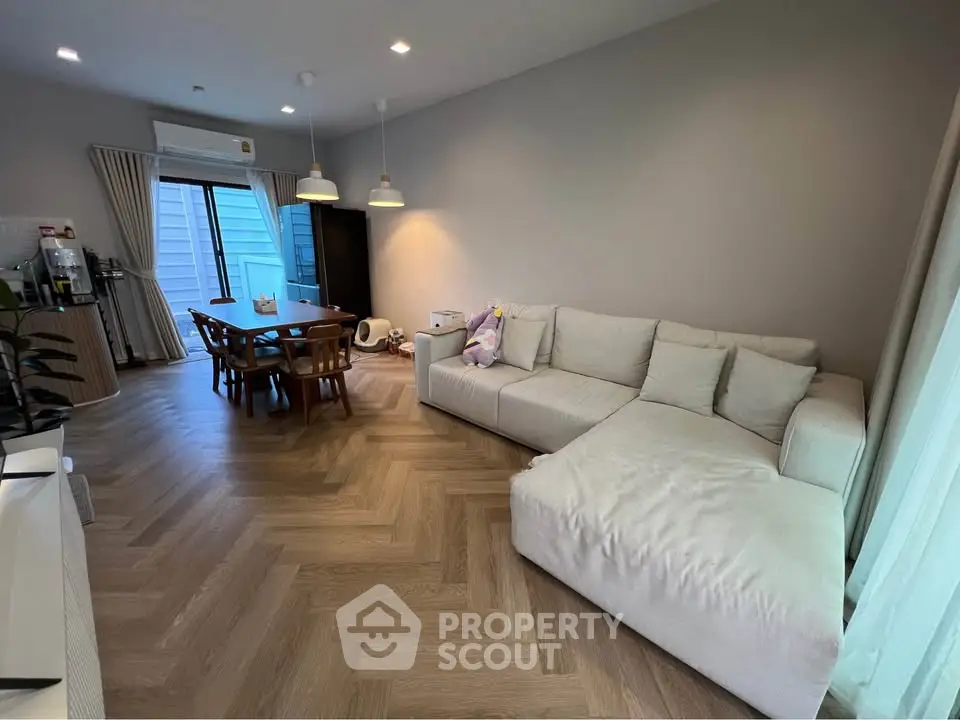 Spacious living room with modern decor and cozy seating area, perfect for relaxation and entertainment.