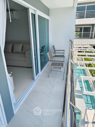 Modern apartment balcony with sleek design and pool view, perfect for relaxation and leisure.