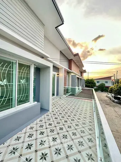 Spacious balcony with stylish tile flooring and modern glass railing, perfect for sunset views.