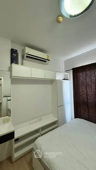 Modern bedroom with air conditioning and ample storage in a sleek apartment.