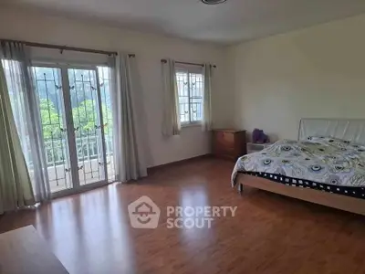 Spacious bedroom with balcony access and wooden flooring