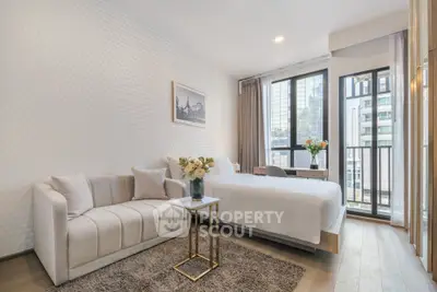 Modern bedroom with elegant decor, featuring a cozy bed, stylish sofa, and a city view balcony.