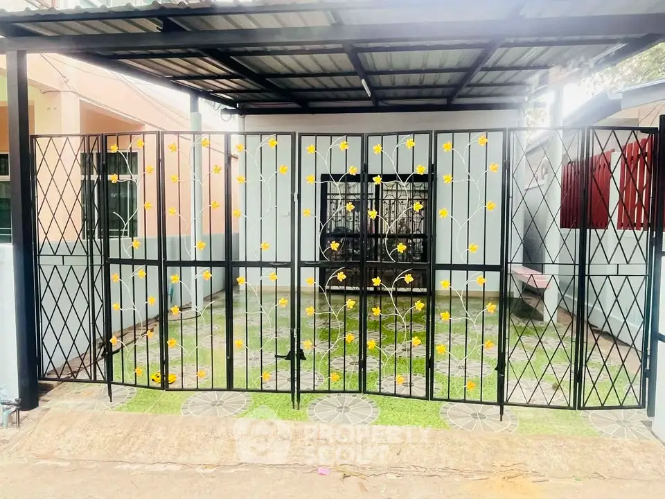Charming home entrance with decorative gate and lush greenery