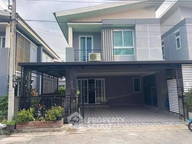 Modern two-story house with spacious driveway and balcony in a suburban neighborhood.