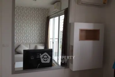 Modern living room with stylish wallpaper and balcony view, featuring air conditioning and sleek furniture.