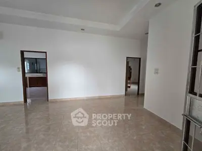 Spacious empty room with tiled flooring and white walls, ideal for customization.