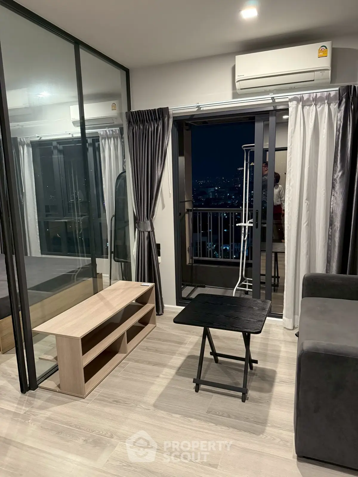 Modern apartment living room with balcony view and sleek furnishings