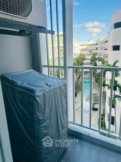 Charming balcony view overlooking a modern pool and lush greenery, perfect for relaxation and leisure.