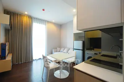 Modern kitchen with sleek design, featuring dining area and built-in appliances.