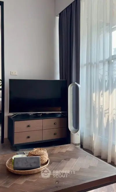 Modern living room with stylish TV stand and floor-to-ceiling curtains, perfect for cozy relaxation.