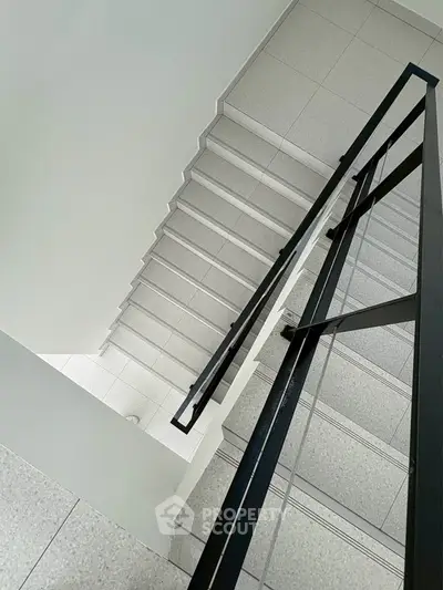 Modern staircase with sleek metal railing in a minimalist building