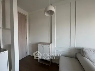 Modern minimalist living room with elegant white panel walls and cozy beige sofa.