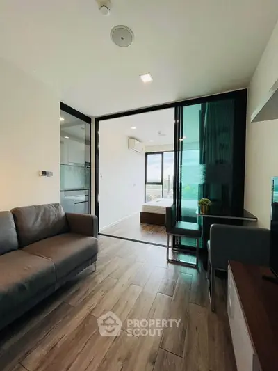 Modern living room with sleek design and open layout, featuring a cozy sofa and dining area with natural light.