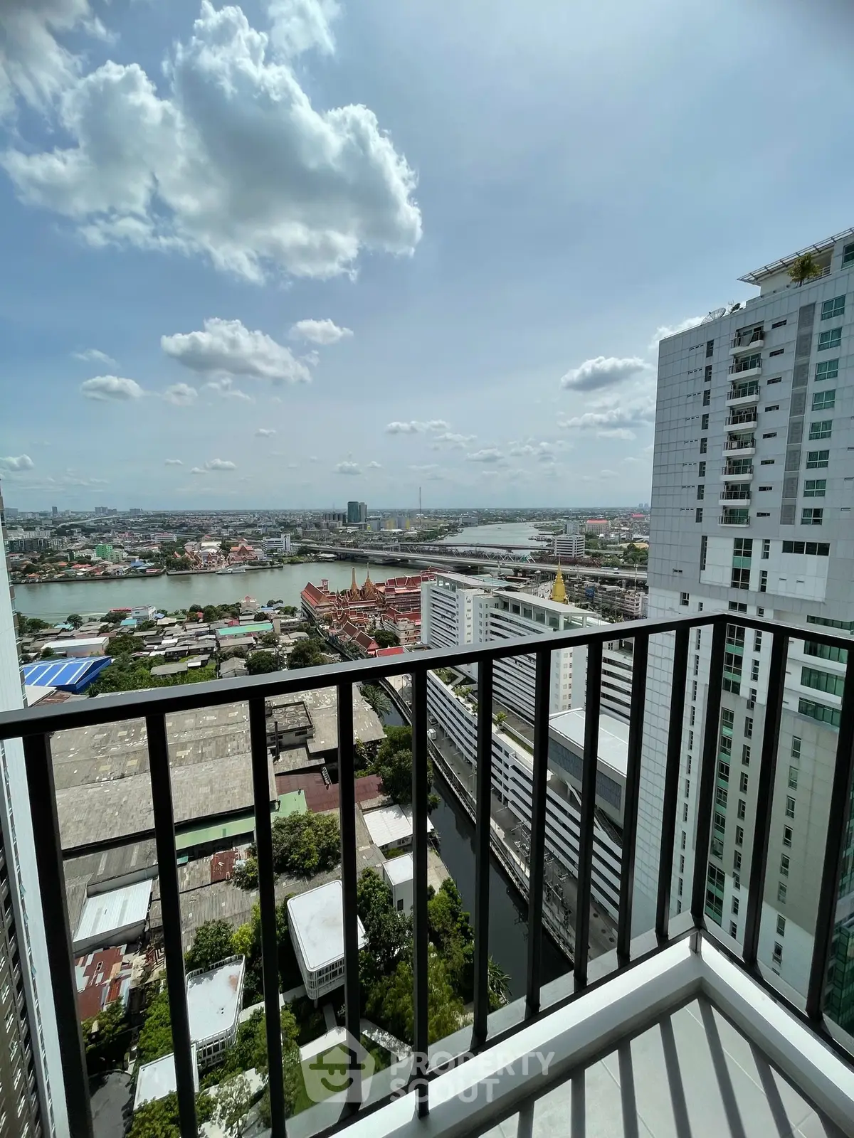 Stunning high-rise balcony view overlooking cityscape and river, perfect for urban living.
