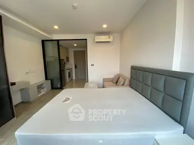 Modern bedroom with stylish decor and in-unit washing machine, perfect for urban living.