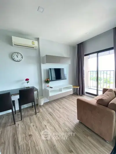 Modern living room with balcony, featuring sleek furniture and natural light.