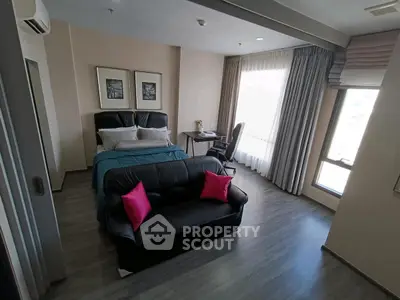 Modern bedroom with stylish decor, featuring a cozy bed, sleek sofa, and large window for natural light.