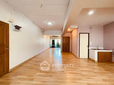 Spacious open layout living area with wooden flooring and modern lighting