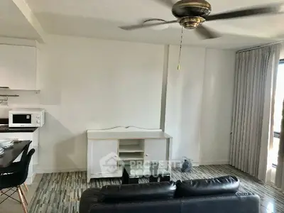 Spacious living room with modern ceiling fan and sleek furniture, perfect for comfortable living.