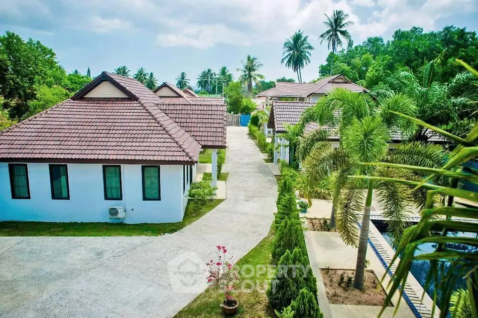 Charming tropical villa complex with lush greenery and traditional architecture.