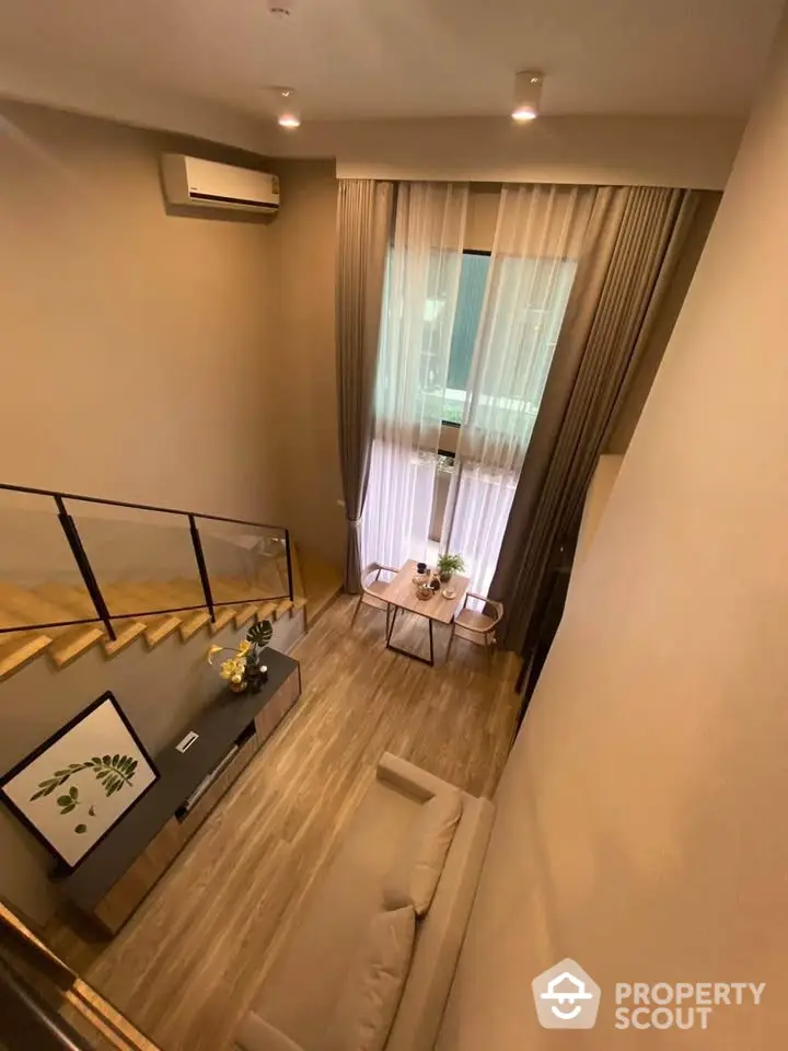 Modern loft-style living room with high ceiling and large window