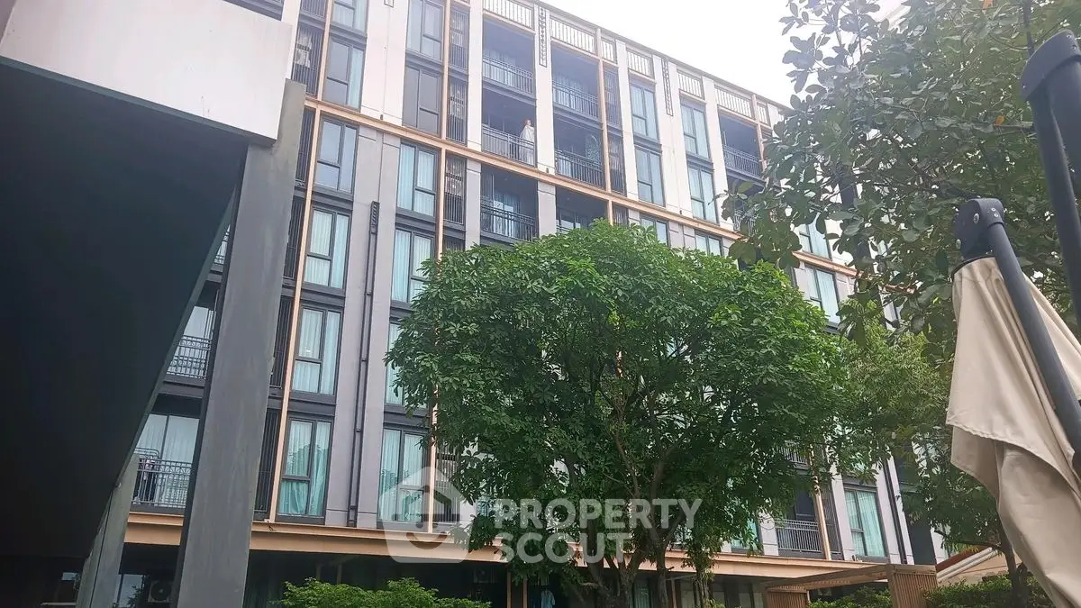 Modern multi-story building with lush greenery and contemporary design.