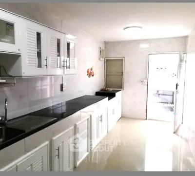 Spacious kitchen with sleek white cabinets and modern appliances, perfect for culinary enthusiasts.