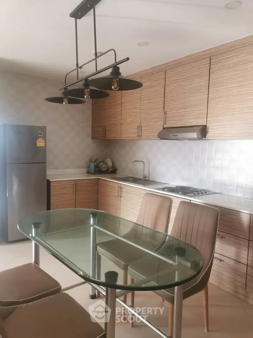 Modern kitchen with sleek wooden cabinets and glass dining table