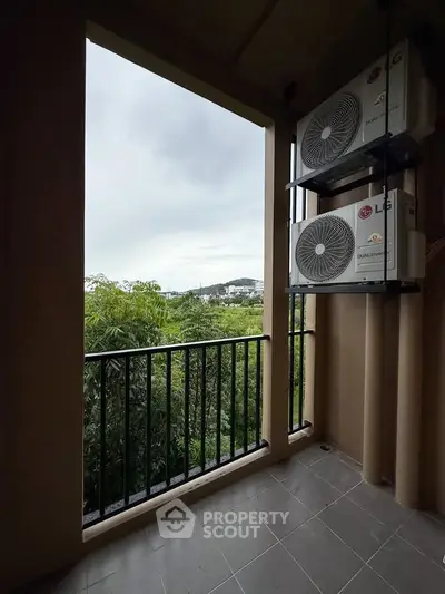 Cozy balcony with lush green view and air conditioning units, perfect for relaxation.