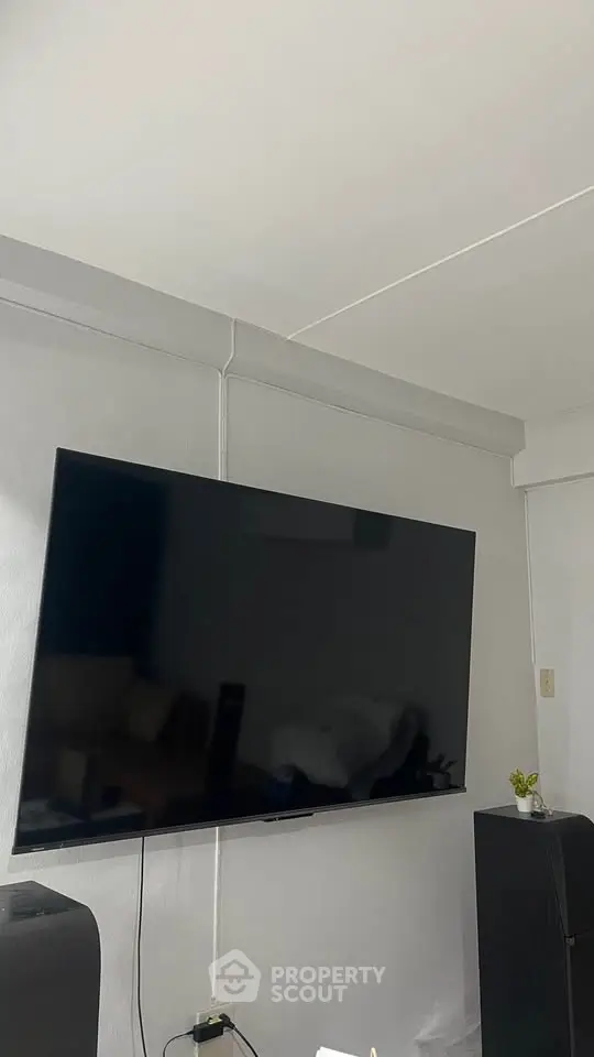 Modern living room with wall-mounted flat-screen TV and sleek sound system.
