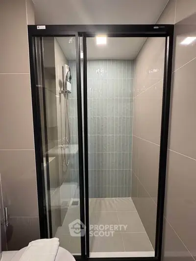 Modern bathroom with sleek glass shower enclosure and contemporary tile design.