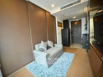 Modern living room with cozy sofa and stylish decor in a compact apartment.